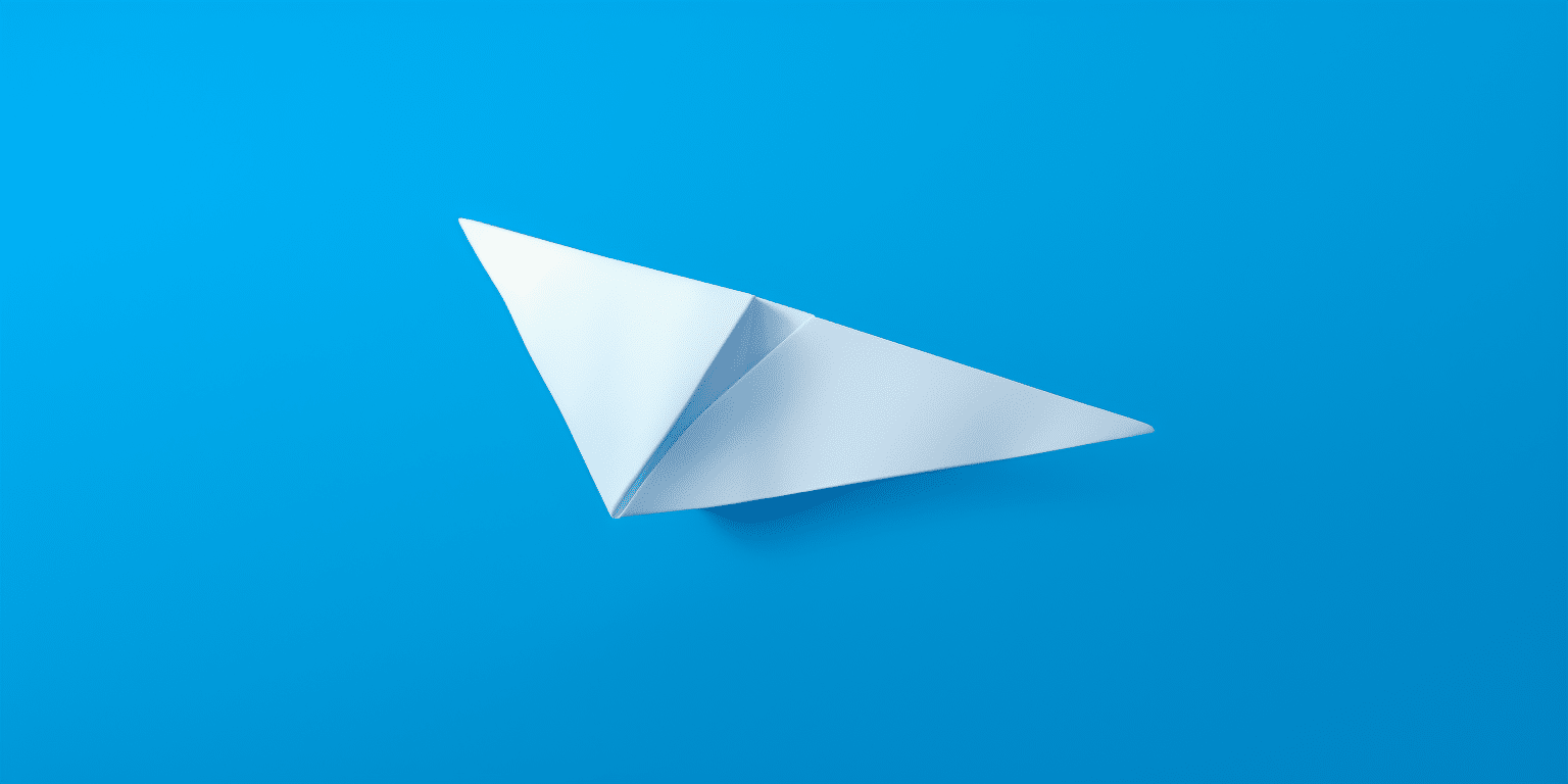 Avión de papel sobre un fondo azul.